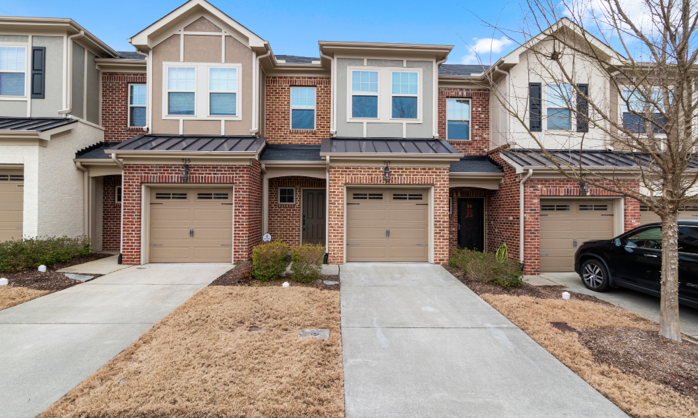 A brick adjacent houses with brown garage door